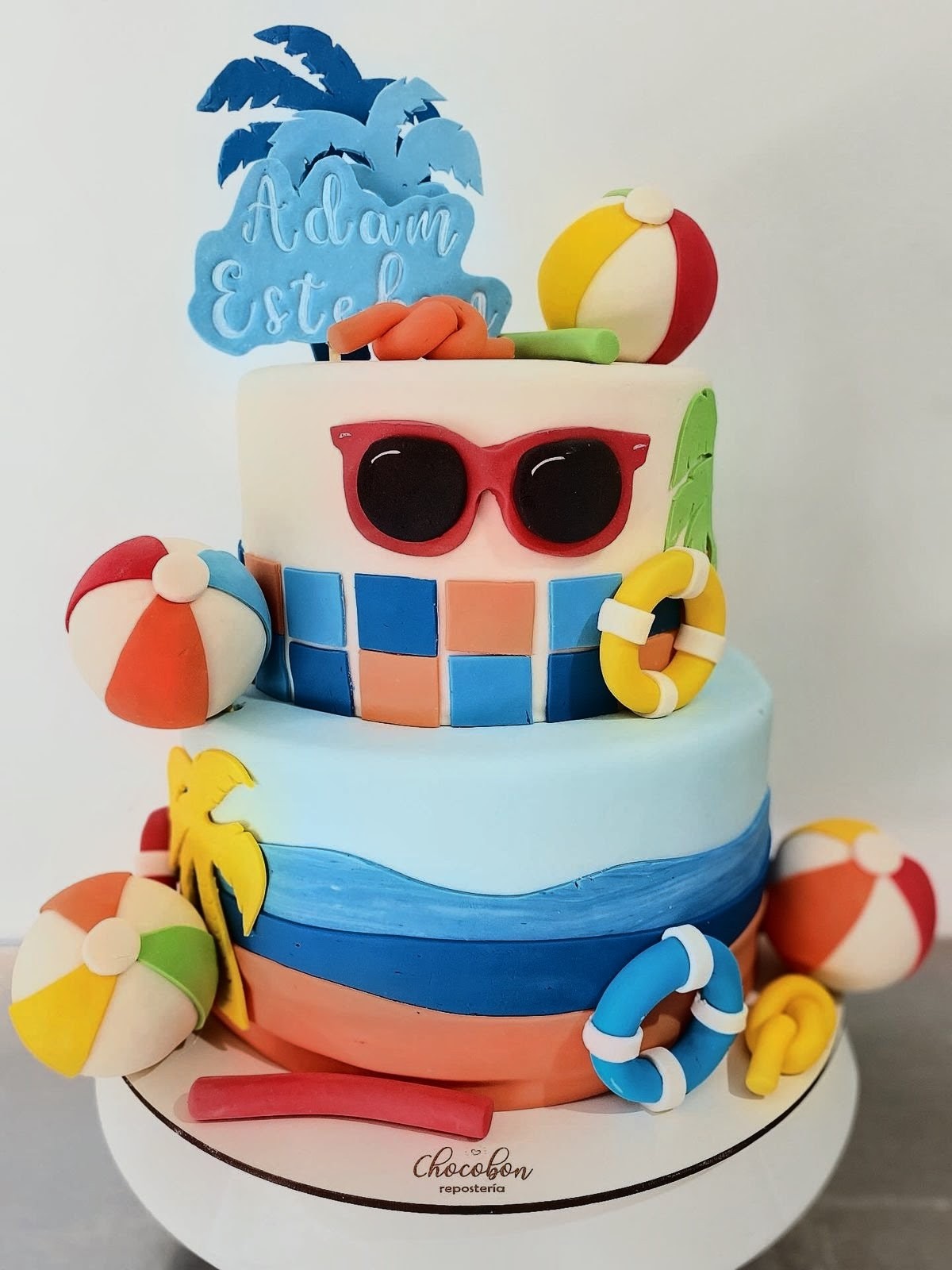 Torta temática de playa con palmeras, pelotas y flotadores