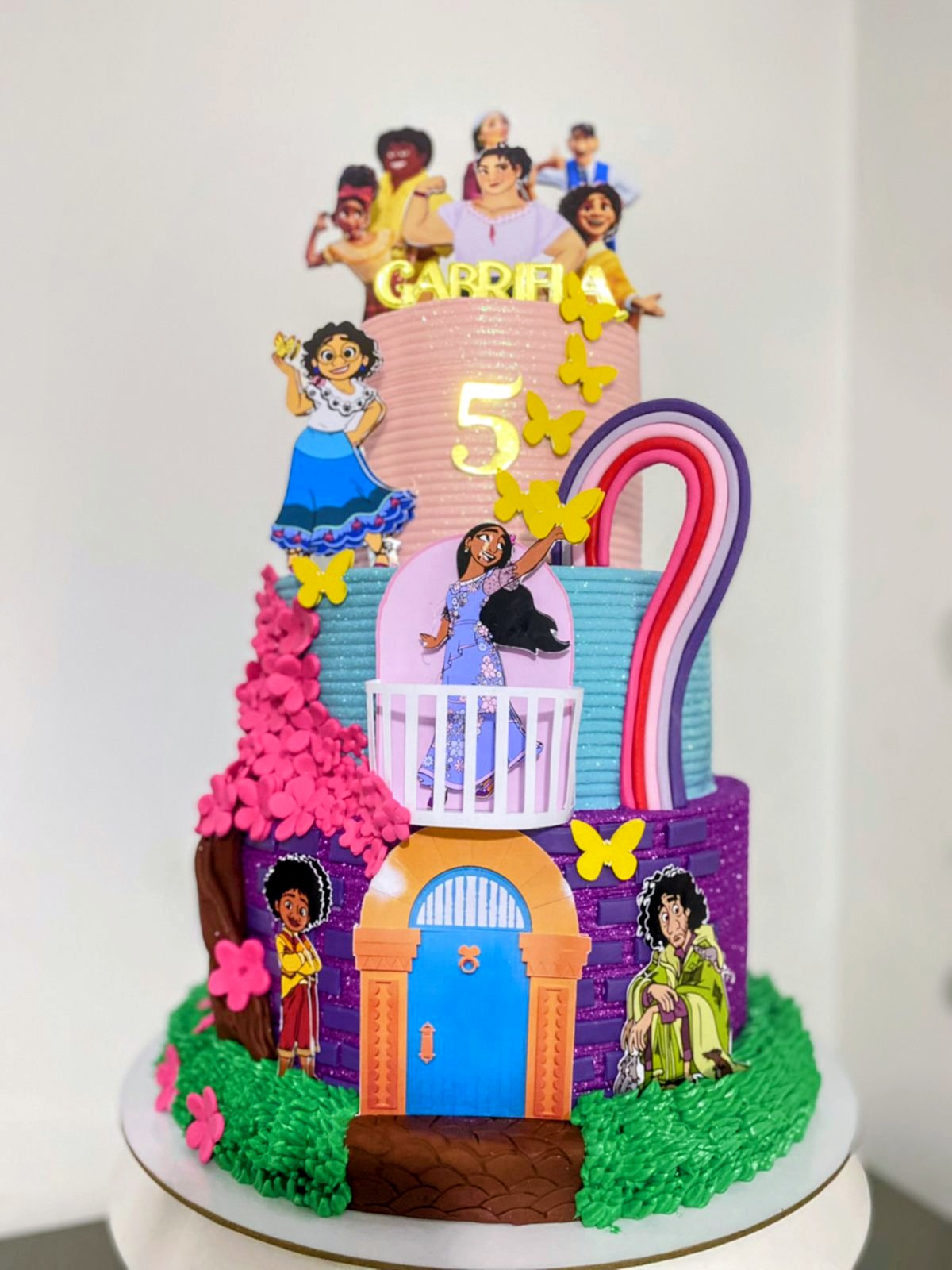 Torta infantil de casita colorida con mariposas y personajes animados