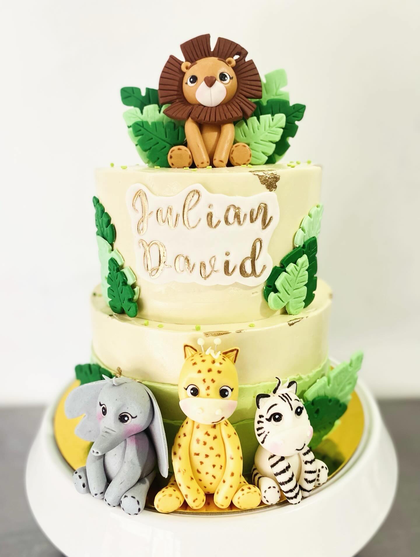 Torta infantil dos pisos temática safari con leoncito, elefante, jirafa y cebra