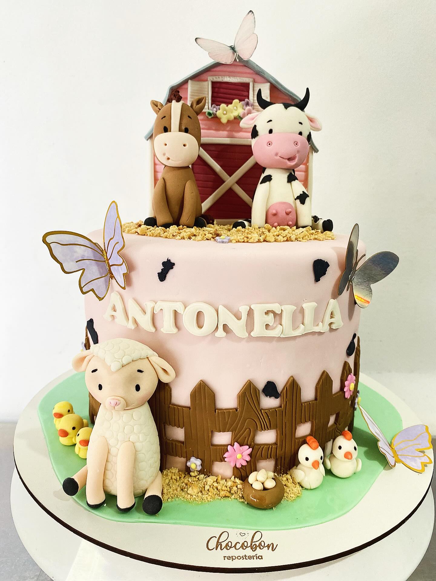 Torta infantil rosa temática granja con vaca, caballo, ovejita y mariposas